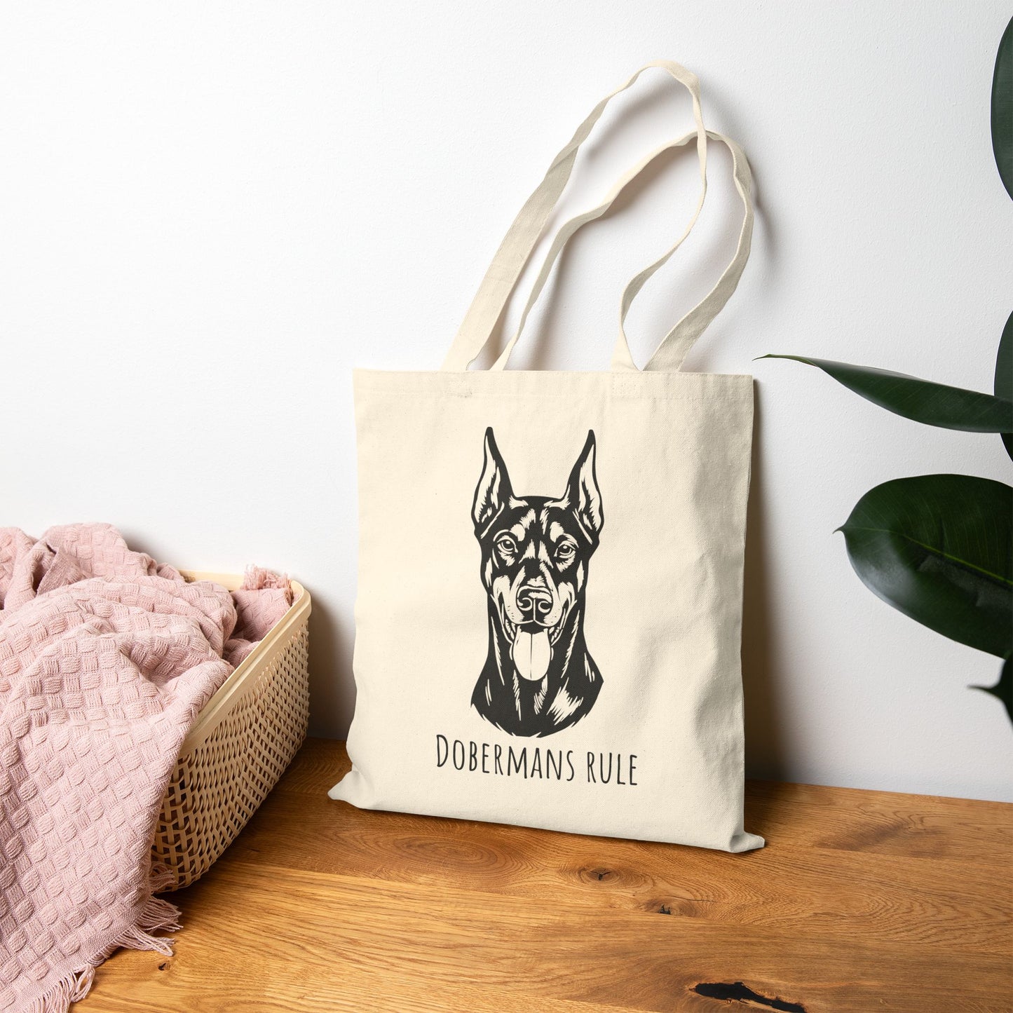 Tote bag with Doberman print and 'Dobermans Rule' text on a wooden surface.