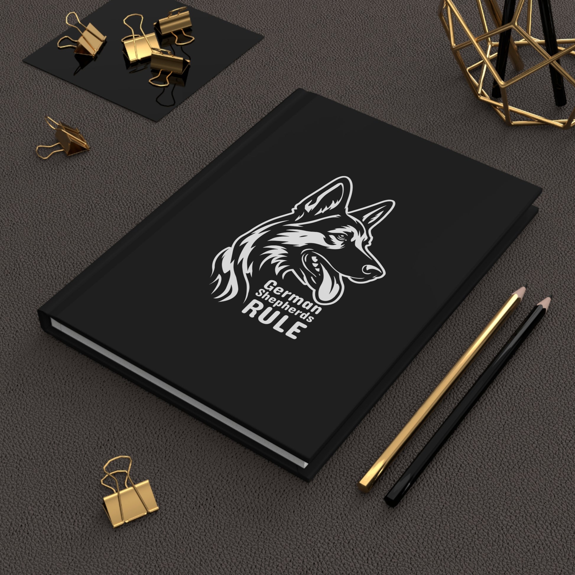 Black notebook with a German Shepherd design and 'German Shepherds Rule' text on a dark surface with office supplies.