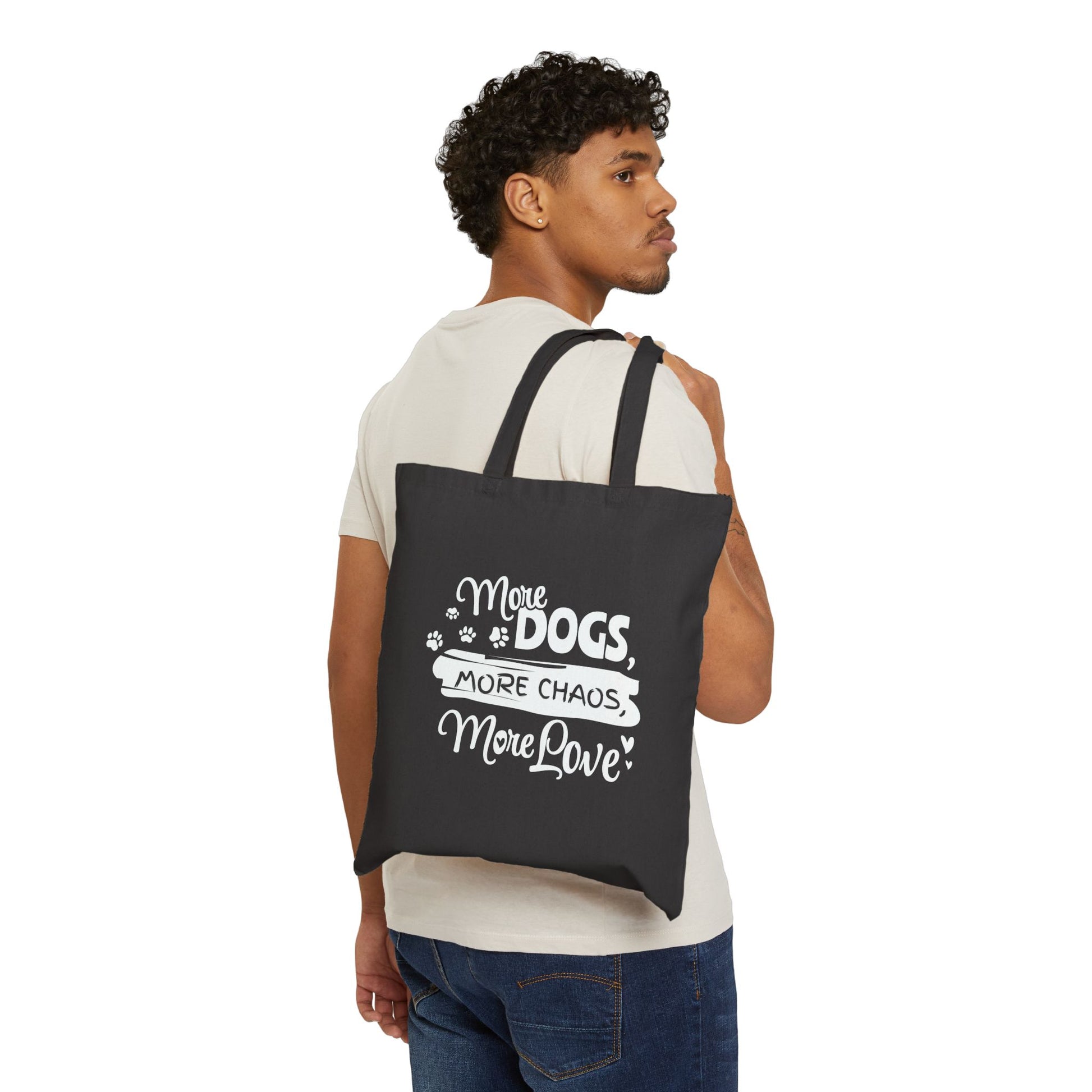 Man carrying a black tote bag with white text and graphics on a white background
