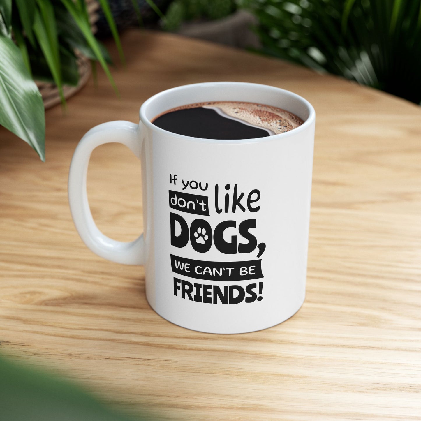 White mug with text 'If you don't like dogs, we can't be friends!' on a wooden table.