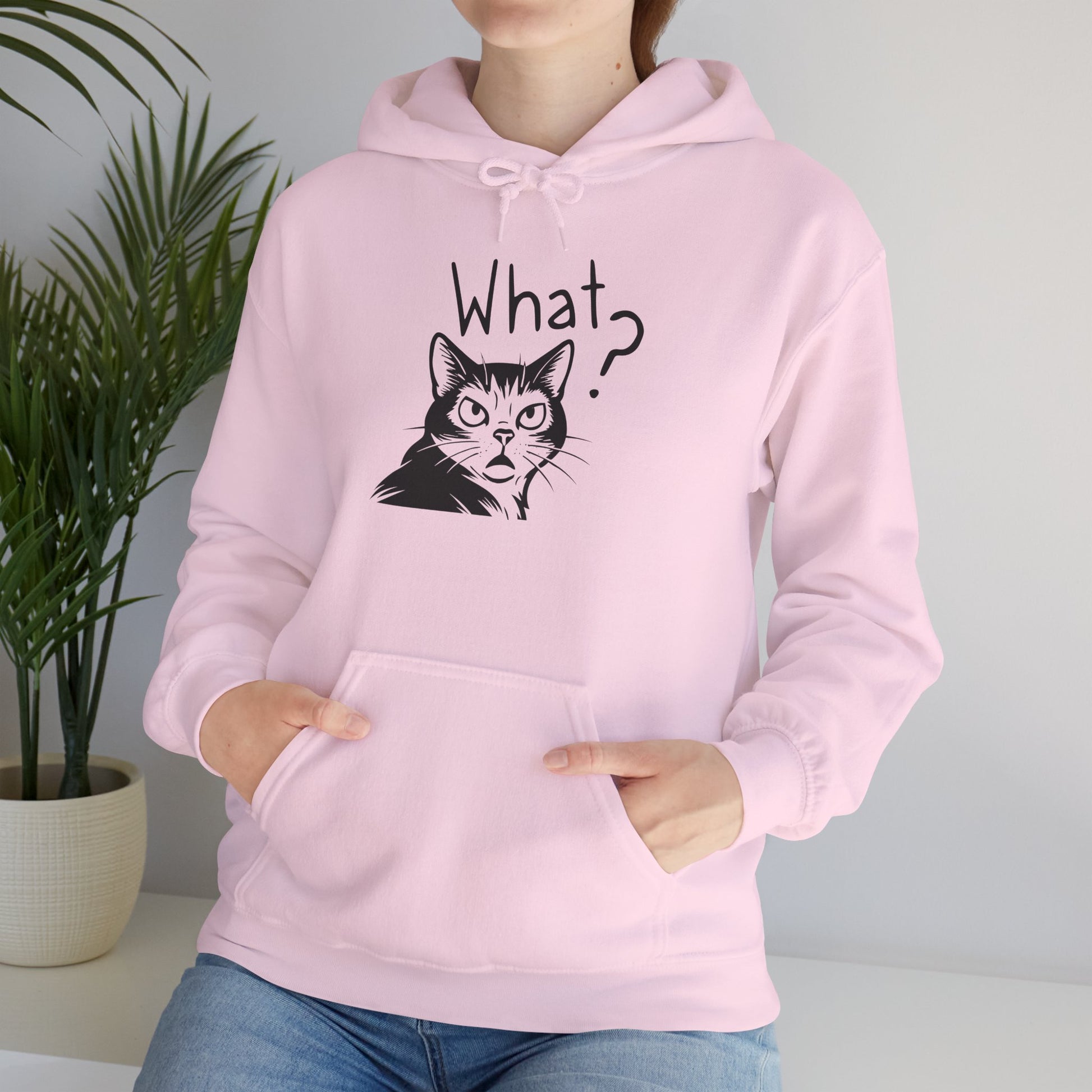 Person wearing a pink hoodie with a cat graphic and 'What?' text.