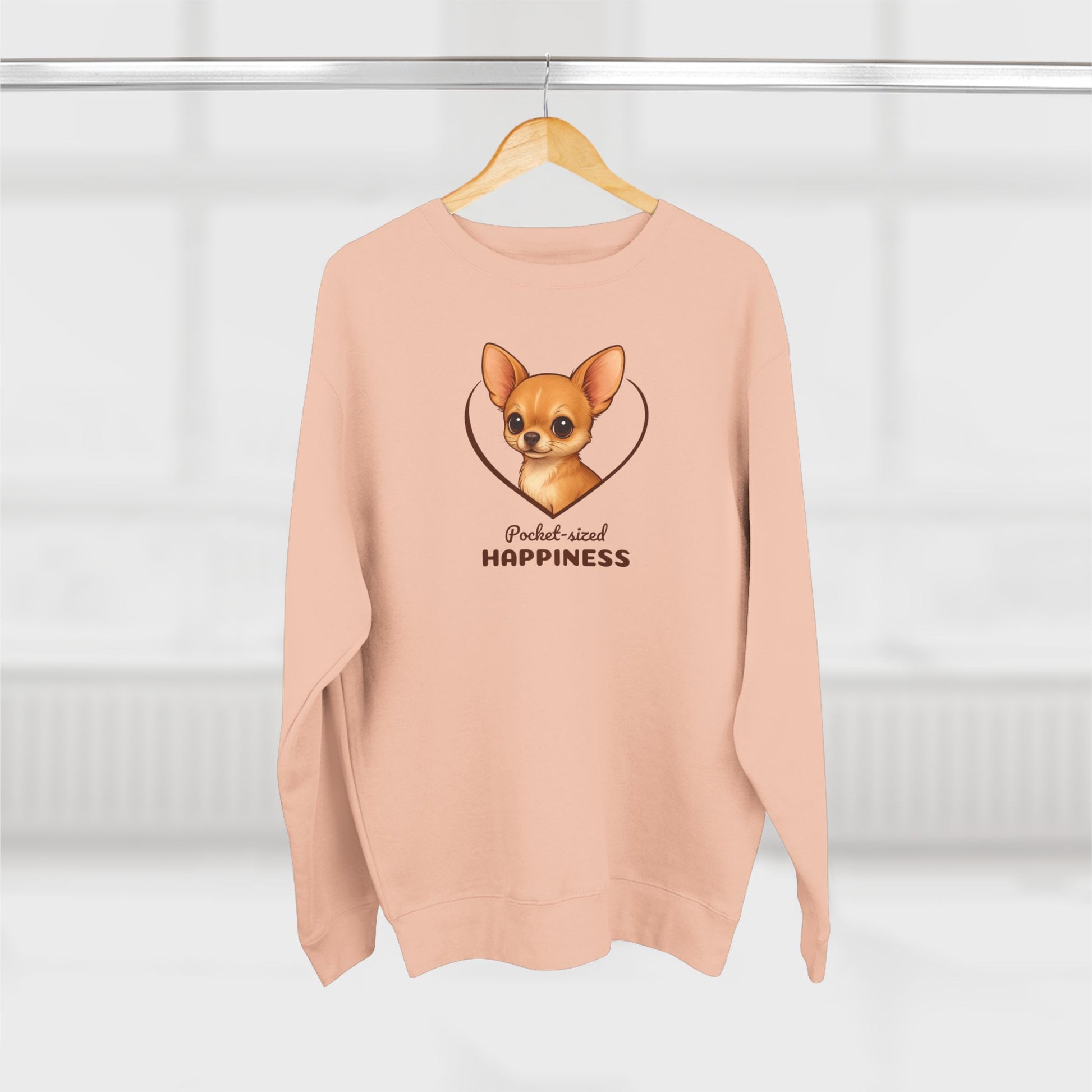 Pink sweatshirt with a dog illustration and text on a hanger against a white background