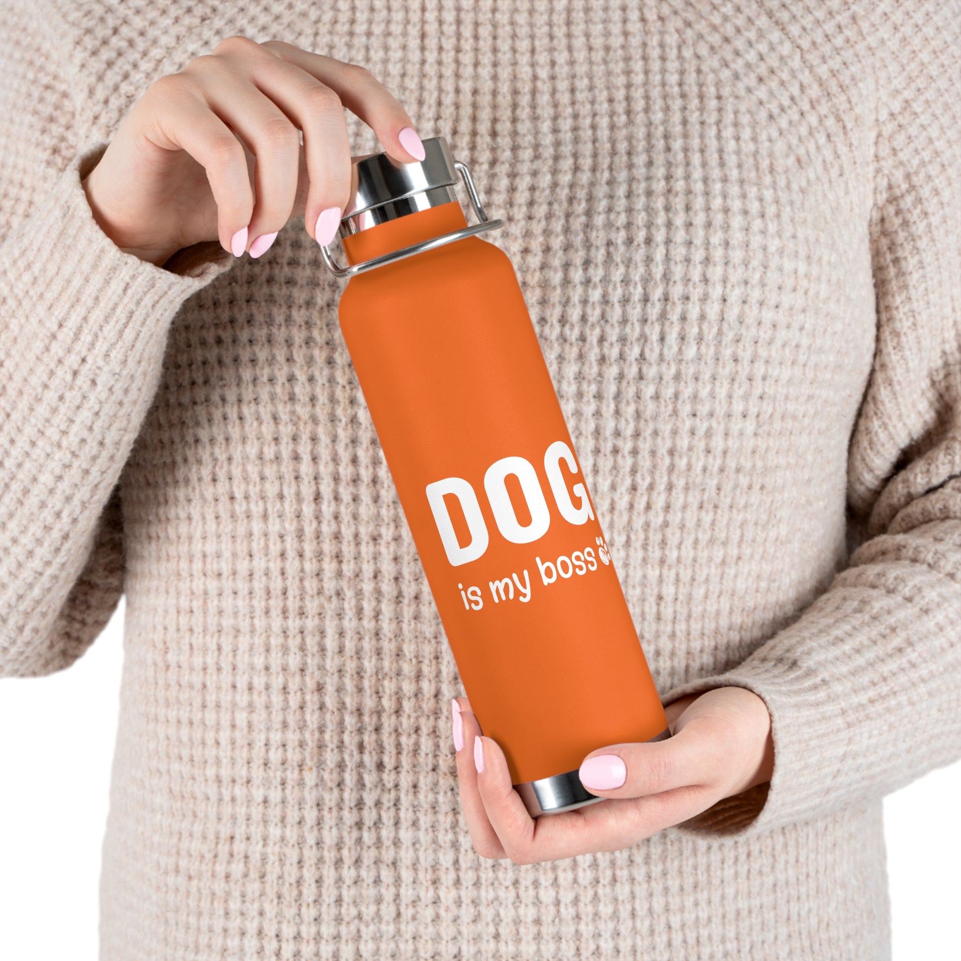 Person holding an orange water bottle with 'DOG is my boss' text
