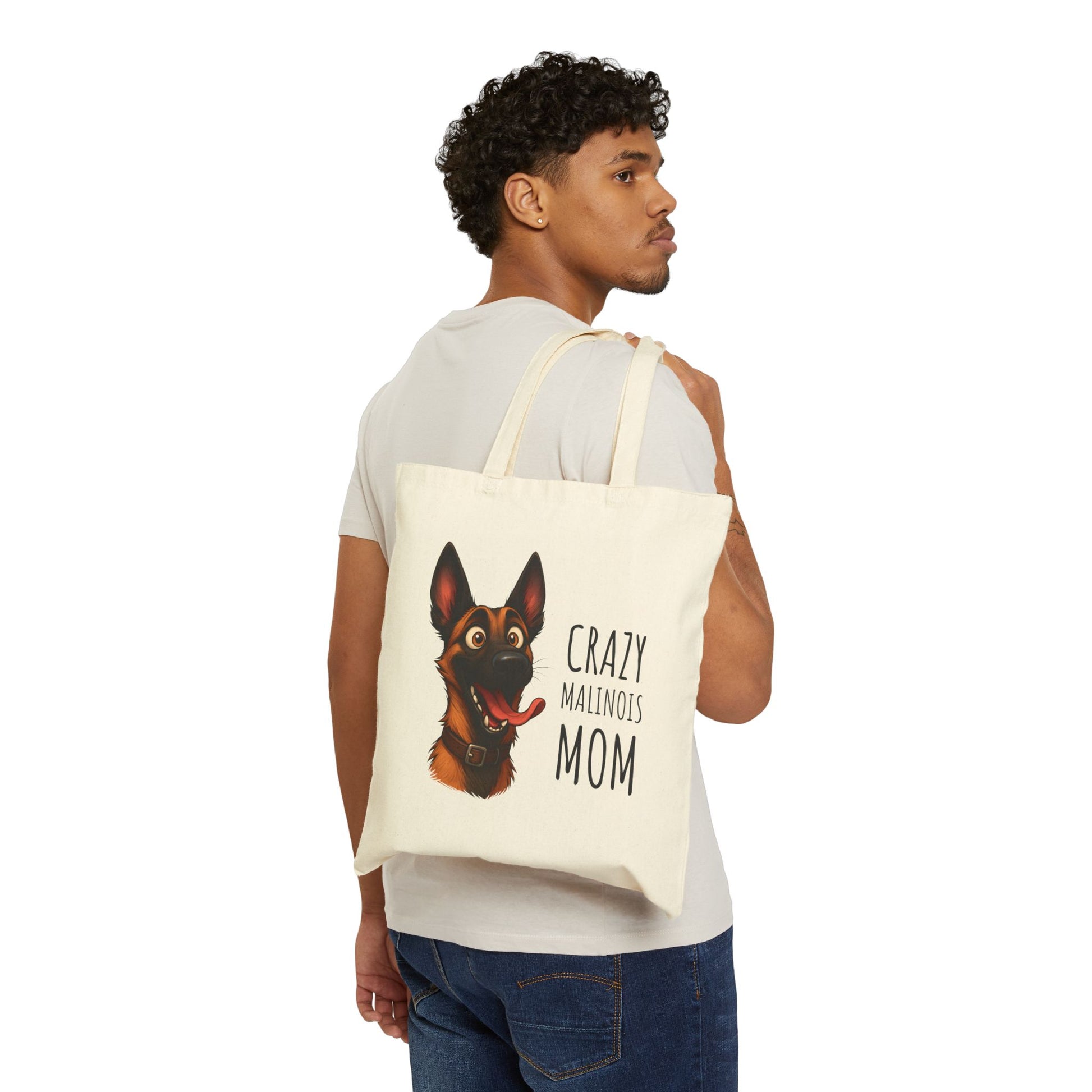 Person holding a tote bag with a dog illustration and text on a white background