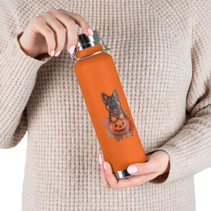 Person holding an orange water bottle with a dog design on a beige background